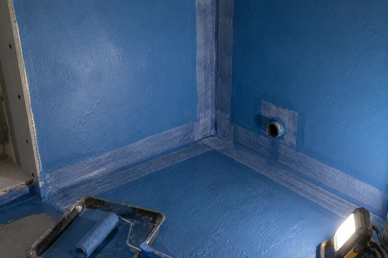 Liquid waterproof membrane and reinforcing tape applied to a steam room corner
