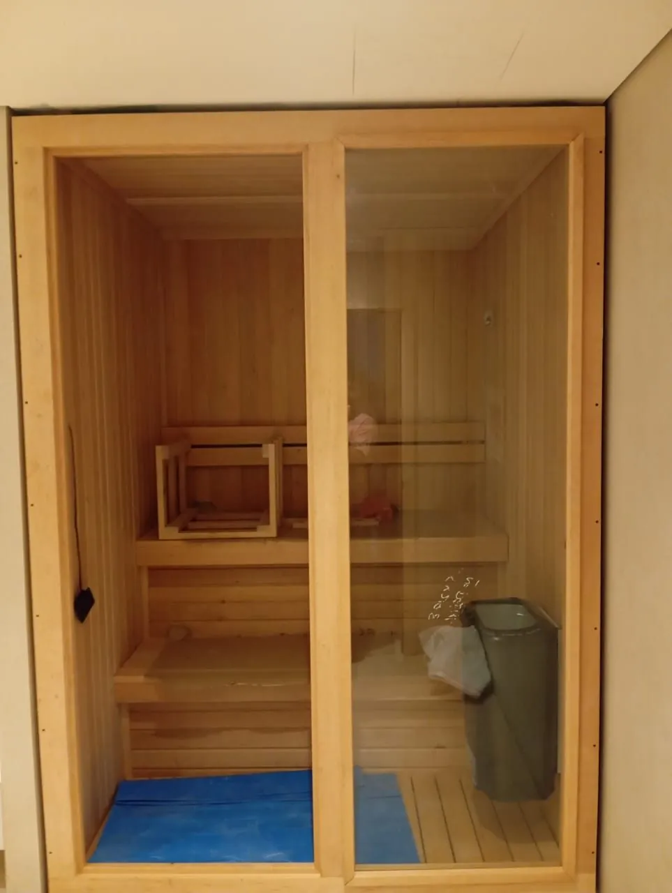 Compact home sauna cabin with a full glass front