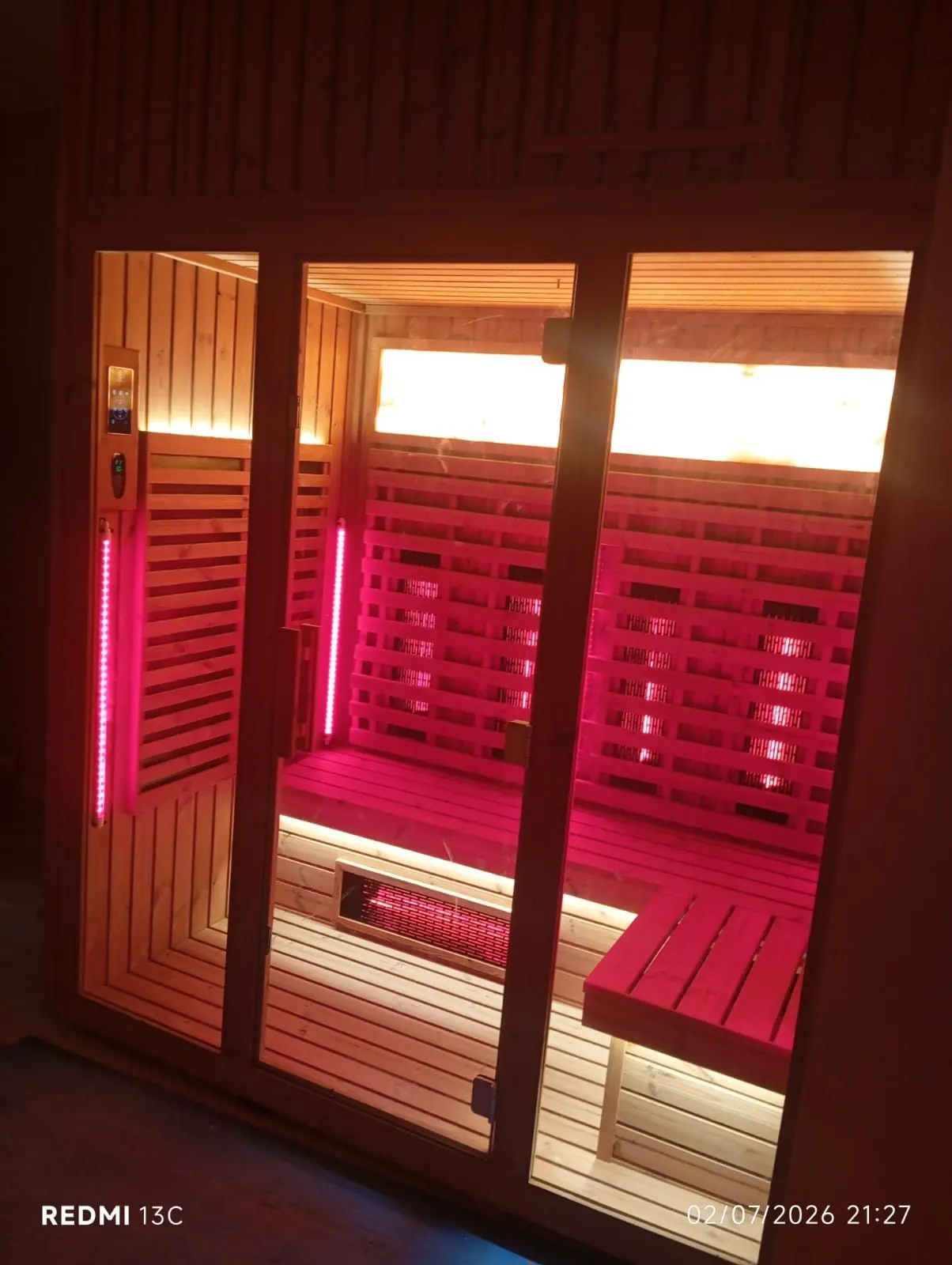 Infrared sauna cabin lit from within, seen through its glass front