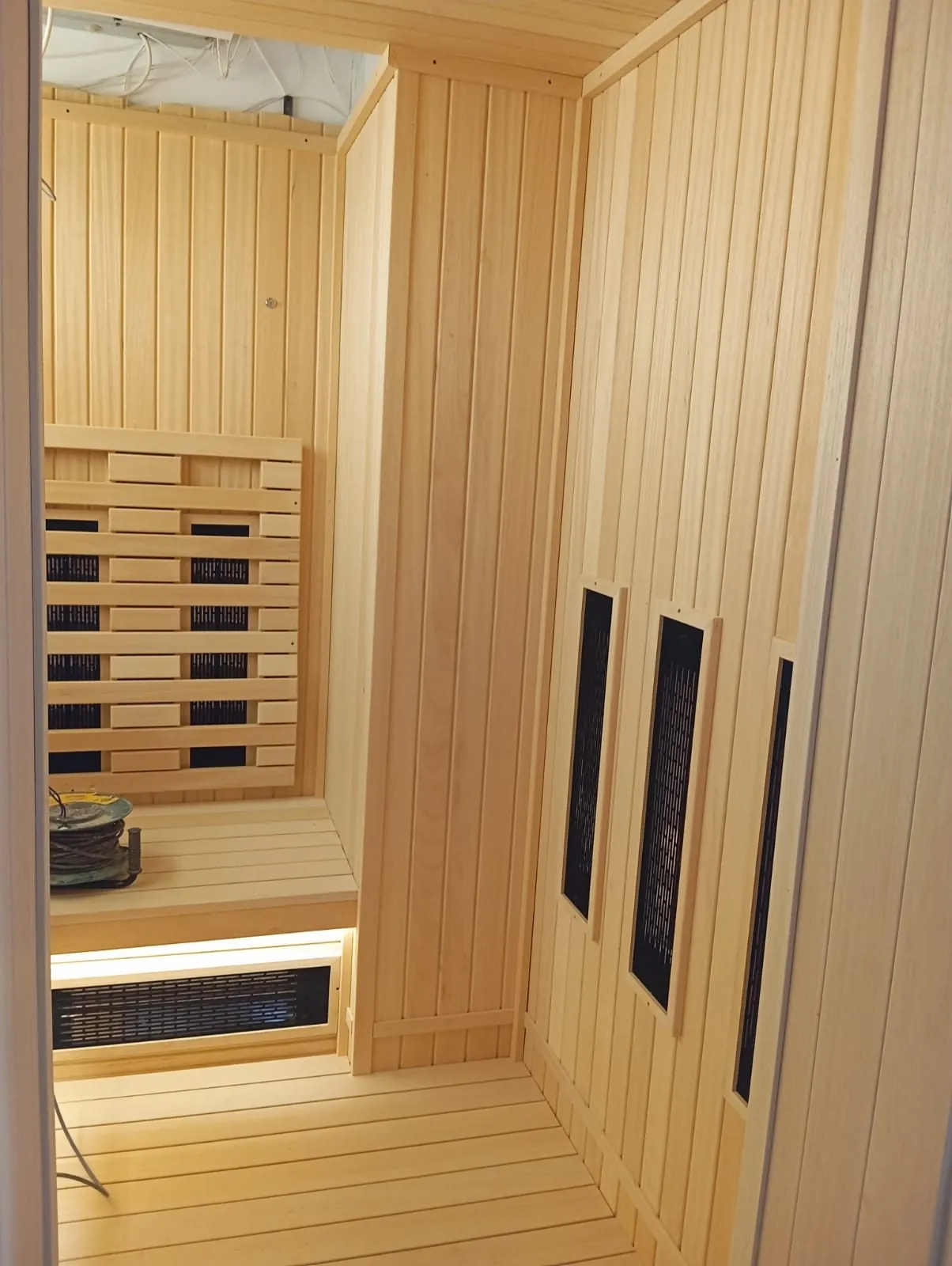 Corner heater panel and bench junction inside an infrared sauna