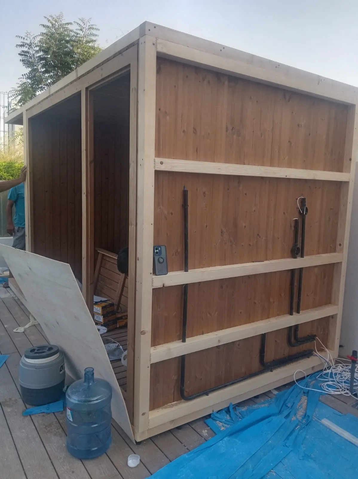Timber frame of an outdoor sauna cabin under construction in a garden