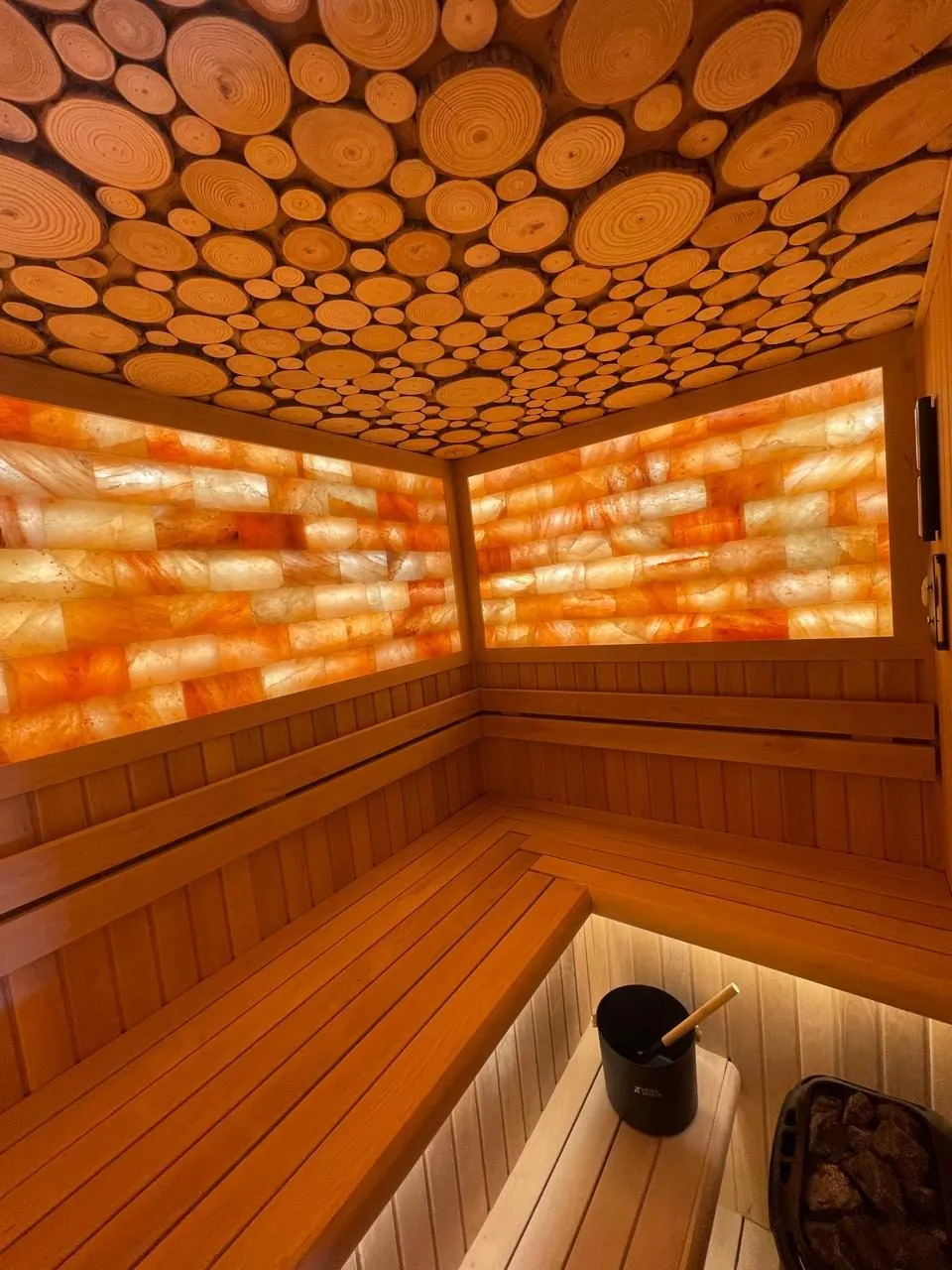 Himalayan salt brick walls and a log-slice ceiling in a completed villa sauna