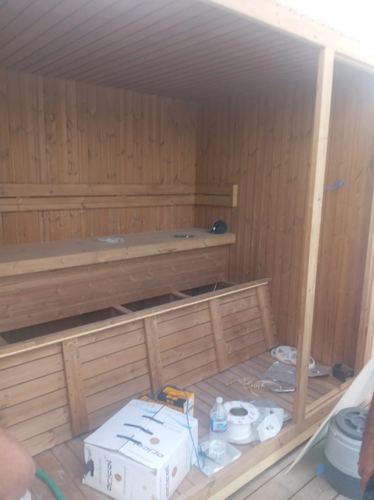 Sauna bench structure part-built inside a clad cabin