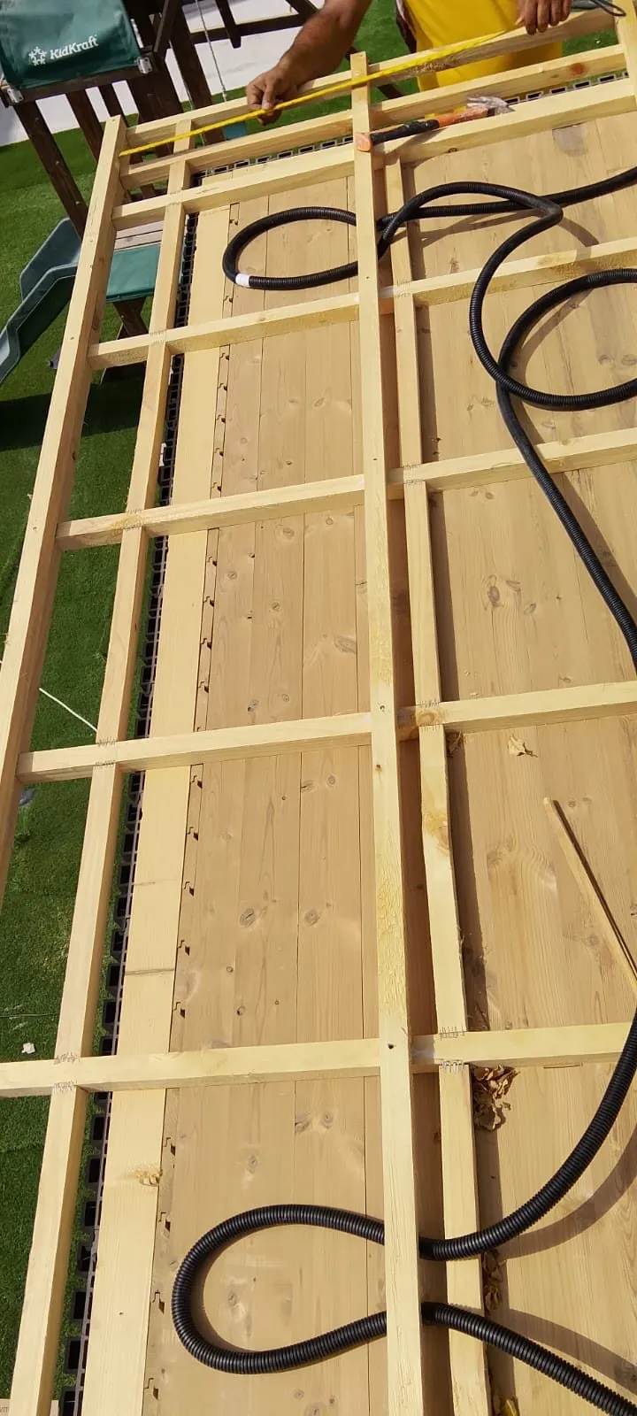Heater supply cable routed through a sauna wall frame before cladding